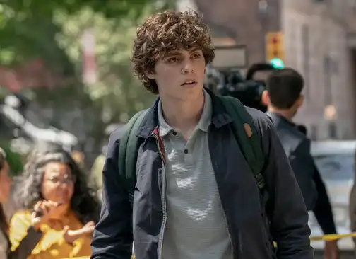 Jack Champion as Ethan Landry looking concerned at a crime scene in Scream 6