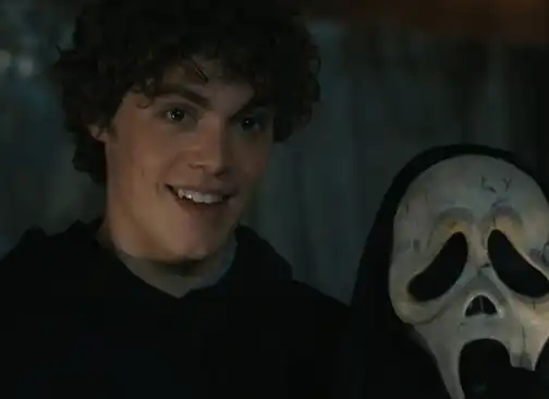 Ethan (Jack Champion) smiling with a Ghostface mask in Scream